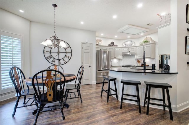dining room featuring dark wood-style flooring, visible vents, baseboards, a chandelier, and recessed lighting