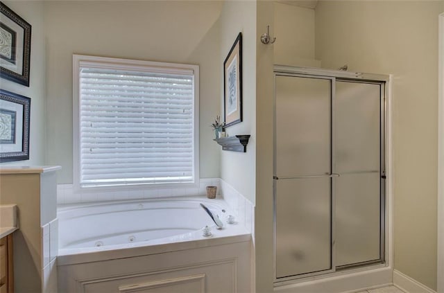 full bathroom with a healthy amount of sunlight, a whirlpool tub, and a stall shower