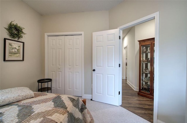 bedroom with baseboards, a closet, and carpet floors
