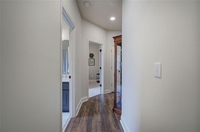 corridor featuring baseboards, recessed lighting, and wood finished floors