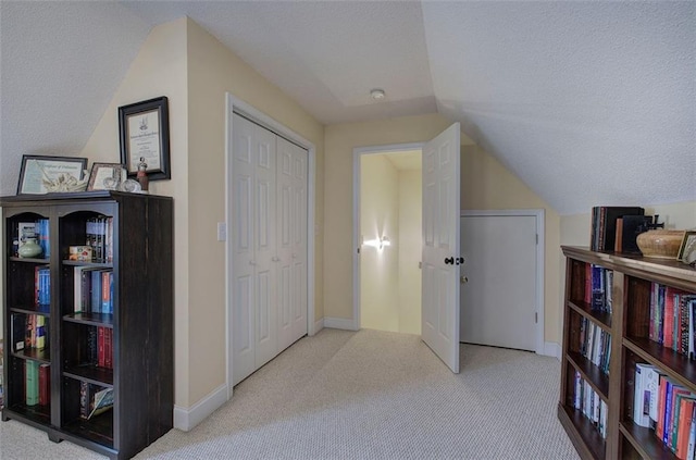 interior space featuring carpet flooring, a textured ceiling, and vaulted ceiling