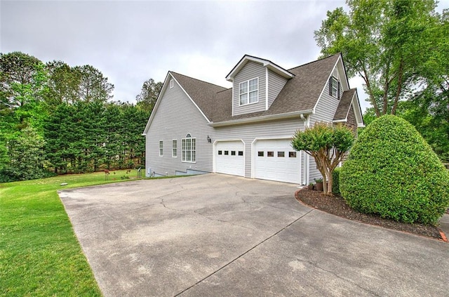 view of side of home with a garage, roof with shingles, a yard, and concrete driveway