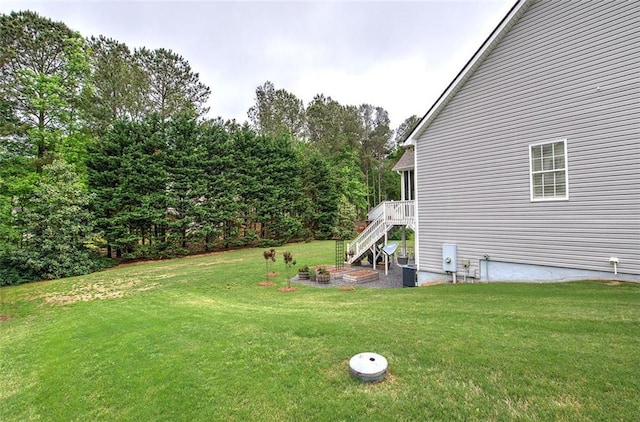 view of yard featuring central AC, stairway, and a deck