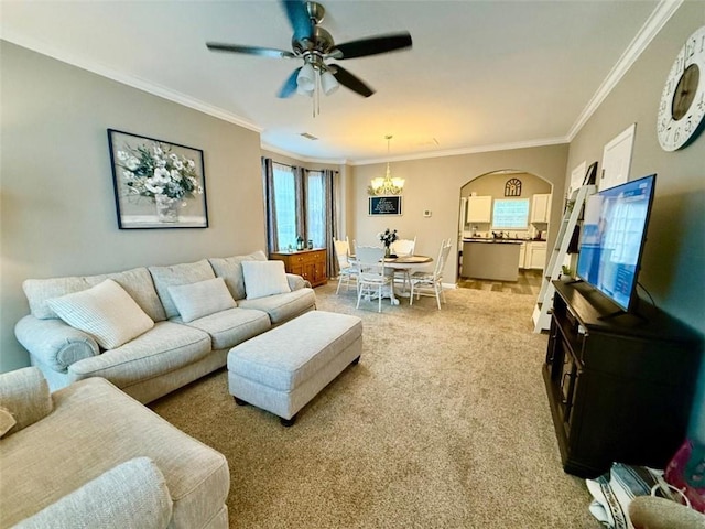 living room with light colored carpet, crown molding, ceiling fan, a chandelier, and arched walkways
