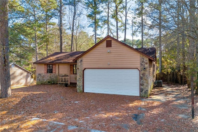 single story home featuring cooling unit and a garage