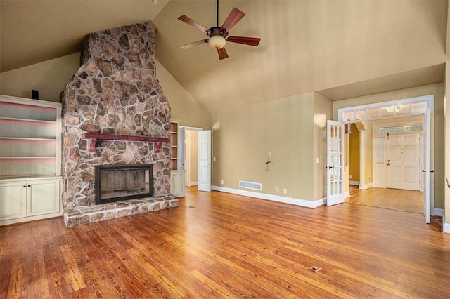 unfurnished living room with ceiling fan, wood-type flooring, a fireplace, and high vaulted ceiling