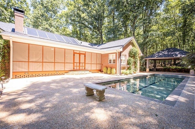 view of pool featuring a gazebo, a patio, and a sunroom