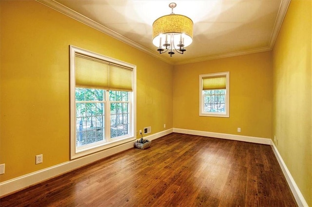 empty room with dark wood-type flooring, ornamental molding, and a notable chandelier