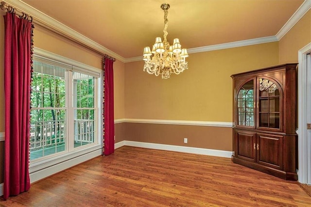 unfurnished dining area featuring crown molding, a chandelier, and hardwood / wood-style floors