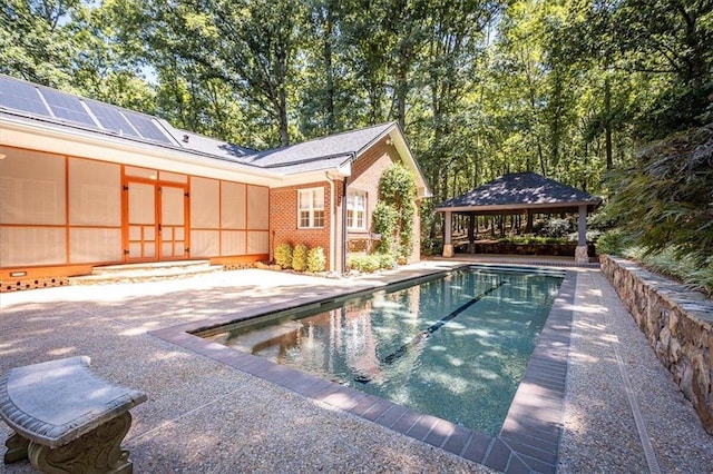 view of swimming pool with a gazebo, a patio area, and a sunroom