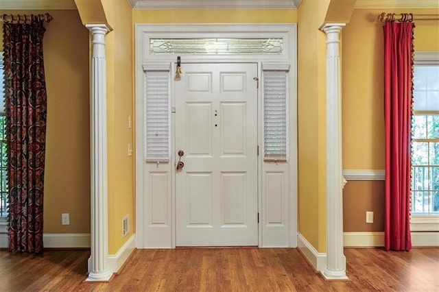 foyer featuring hardwood / wood-style flooring, a wealth of natural light, and ornate columns