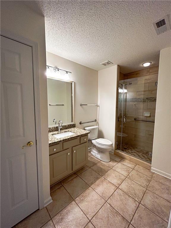 3077 Oakside Cir, Alpharetta, GA 30004 - full bath featuring toilet, a shower stall, tile patterned flooring, vanity, and a textured ceiling