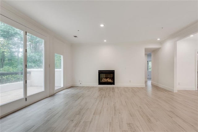 unfurnished living room featuring light hardwood / wood-style flooring and crown molding