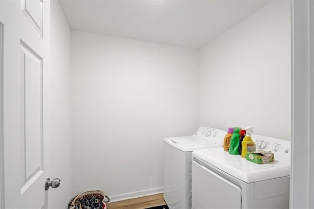 washroom with wood-type flooring and washing machine and dryer