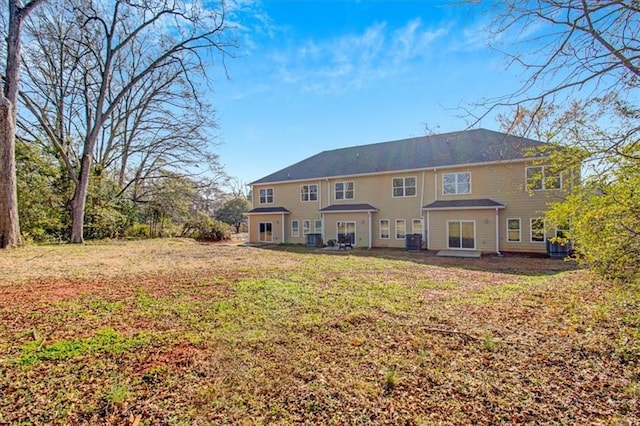 rear view of house featuring a yard and cooling unit