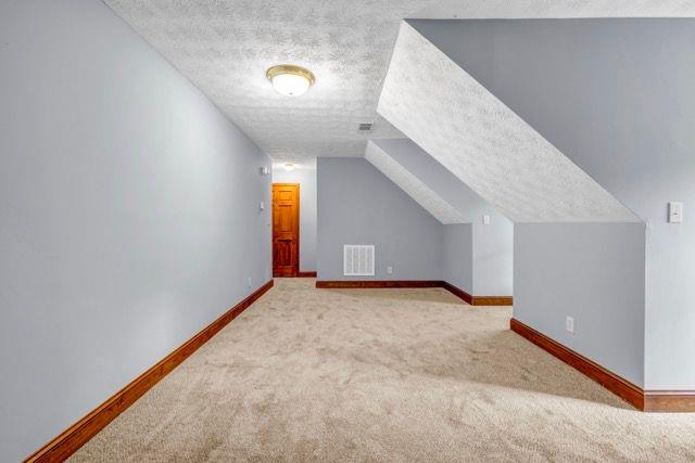 362 Clyde Ct, Mcdonough, GA 30252 - bonus room featuring carpet, a textured ceiling, and baseboards