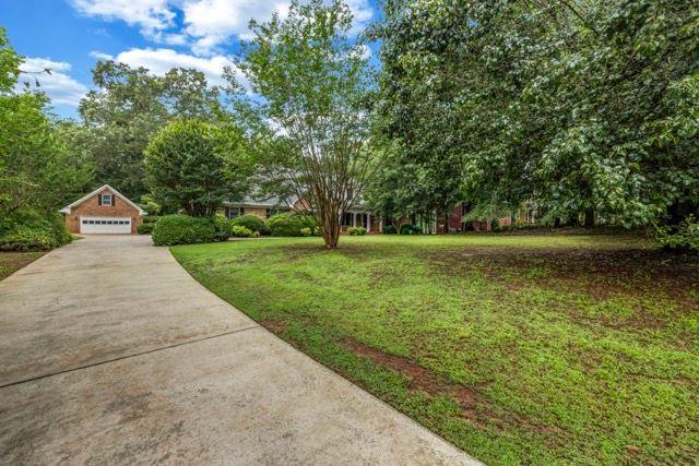 362 Clyde Ct, Mcdonough, GA 30252 - view of green lawn with a garage and concrete driveway