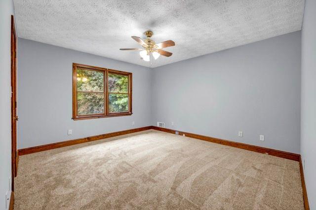 362 Clyde Ct, Mcdonough, GA 30252 - carpeted empty room featuring a ceiling fan, baseboards, and a textured ceiling