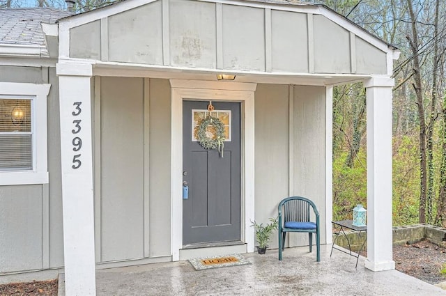 entrance to property featuring a shingled roof