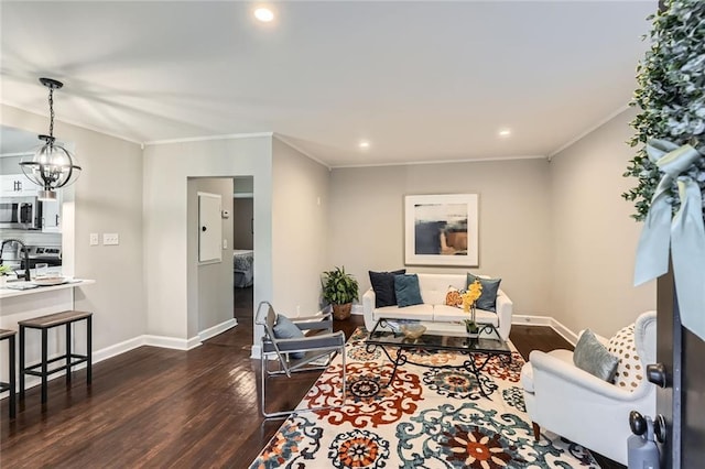 living area featuring baseboards, an inviting chandelier, dark wood finished floors, and ornamental molding