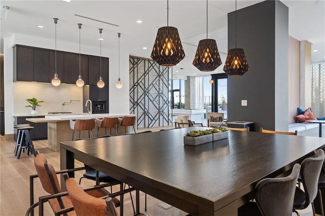 dining space with light hardwood / wood-style floors and sink