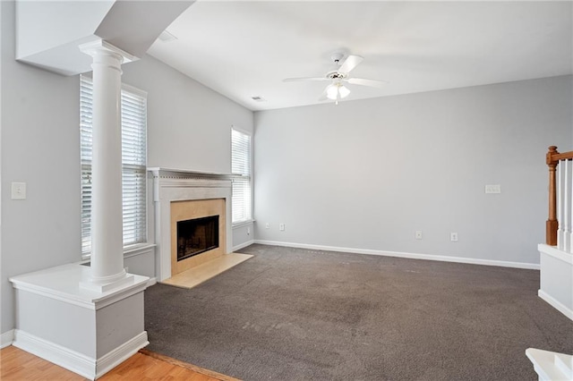 unfurnished living room featuring ceiling fan, plenty of natural light, a high end fireplace, and carpet flooring