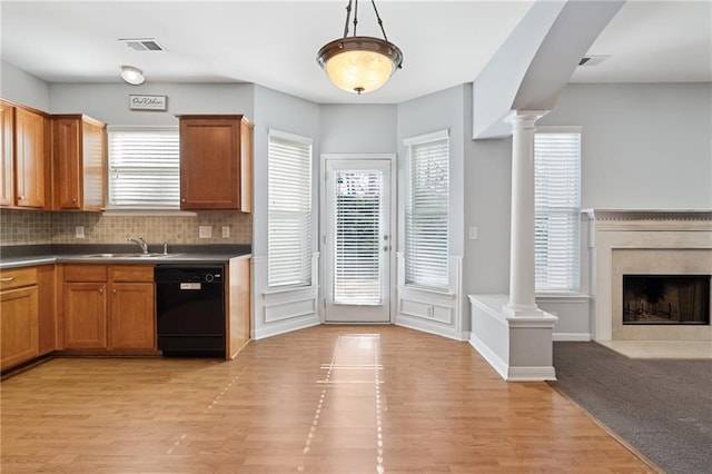 kitchen with dishwasher, light hardwood / wood-style floors, sink, backsplash, and hanging light fixtures