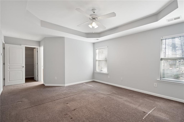 unfurnished room with ceiling fan, carpet, and a raised ceiling