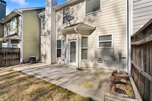 rear view of house with central AC, a patio area, and a yard