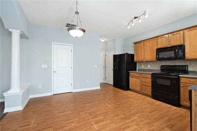 kitchen featuring black appliances, light hardwood / wood-style floors, decorative backsplash, hanging light fixtures, and decorative columns