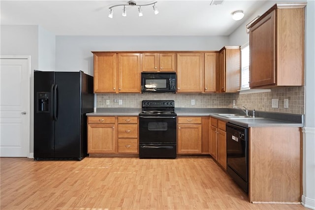 kitchen featuring light hardwood / wood-style floors, sink, black appliances, and tasteful backsplash