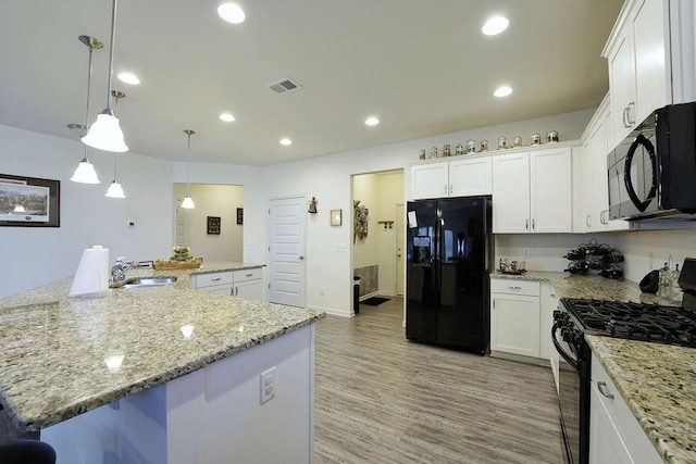 kitchen featuring hanging light fixtures, sink, white cabinets, and black appliances