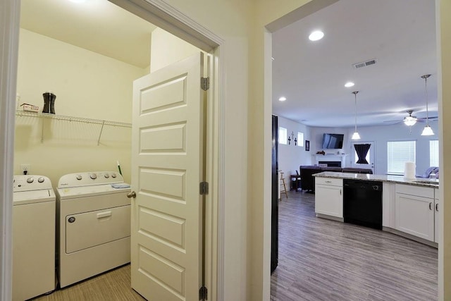 washroom with washing machine and dryer, sink, ceiling fan, and light wood-type flooring