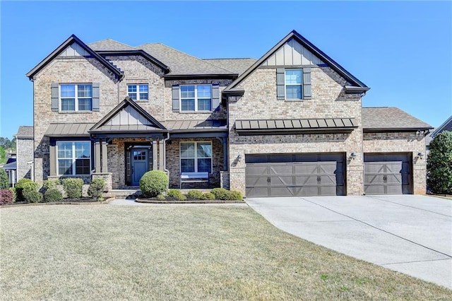 craftsman house with driveway, a standing seam roof, a front lawn, and brick siding