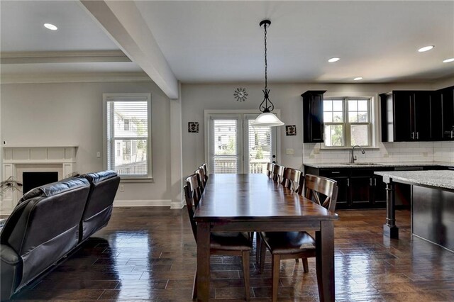 dining space with baseboards, ornamental molding, a fireplace, recessed lighting, and dark wood-style floors