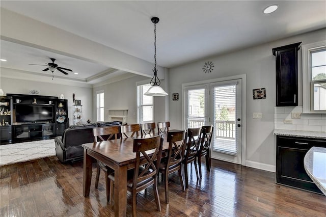 dining room with a healthy amount of sunlight, baseboards, and dark wood finished floors