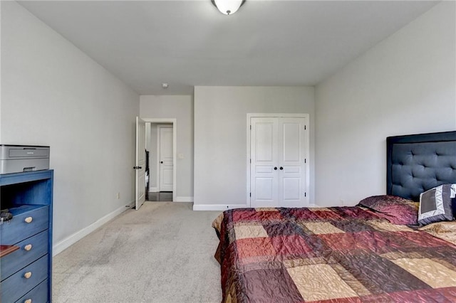 bedroom with a closet, baseboards, and light carpet