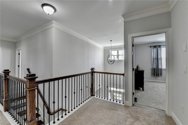 corridor with crown molding, an upstairs landing, and carpet floors