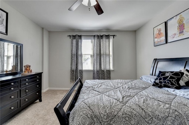 bedroom with ceiling fan, light carpet, and baseboards