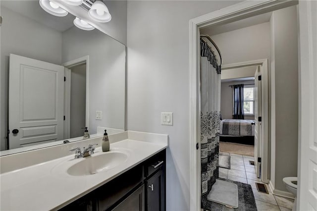 full bathroom featuring toilet, tile patterned flooring, baseboards, and vanity