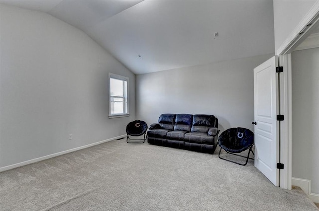 carpeted living area with baseboards and vaulted ceiling