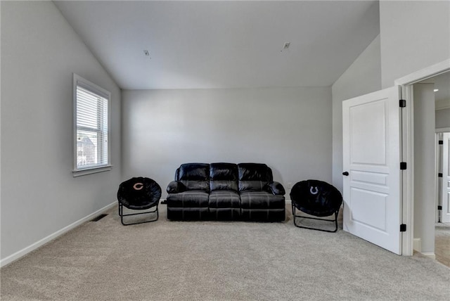 living area with visible vents, baseboards, carpet, and vaulted ceiling