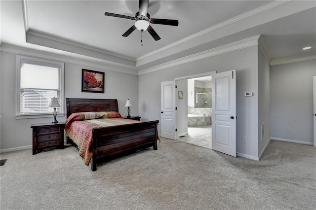 bedroom with a tray ceiling, carpet flooring, baseboards, and crown molding