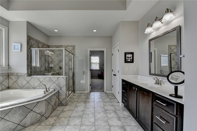 bathroom featuring baseboards, a shower stall, recessed lighting, vanity, and a garden tub