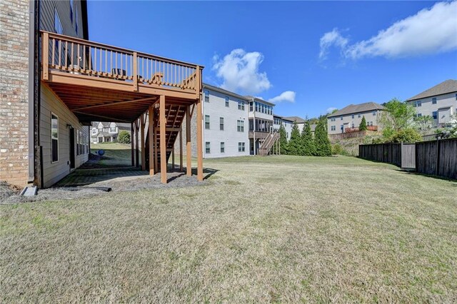 view of yard with a residential view, stairway, a deck, and fence