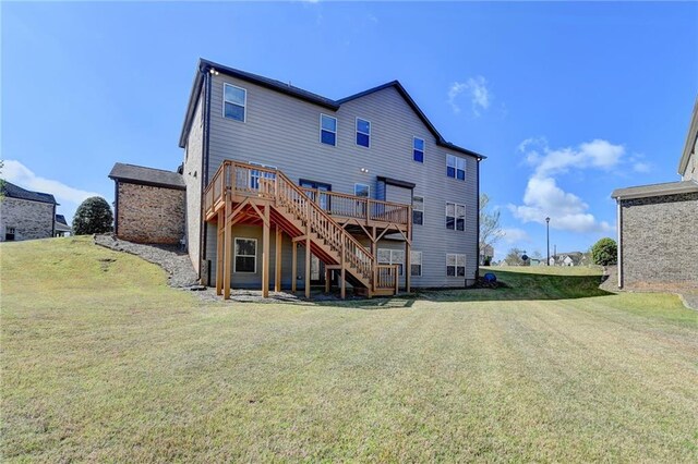 back of house featuring a lawn, a deck, and stairs