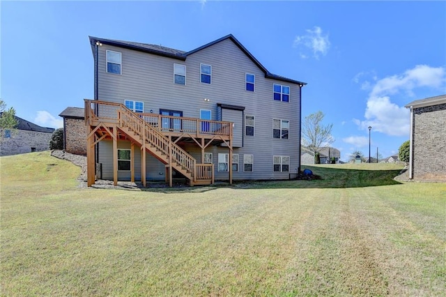 rear view of house featuring stairs, a wooden deck, and a lawn