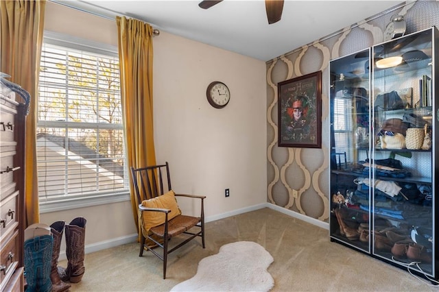 living area with light carpet and ceiling fan