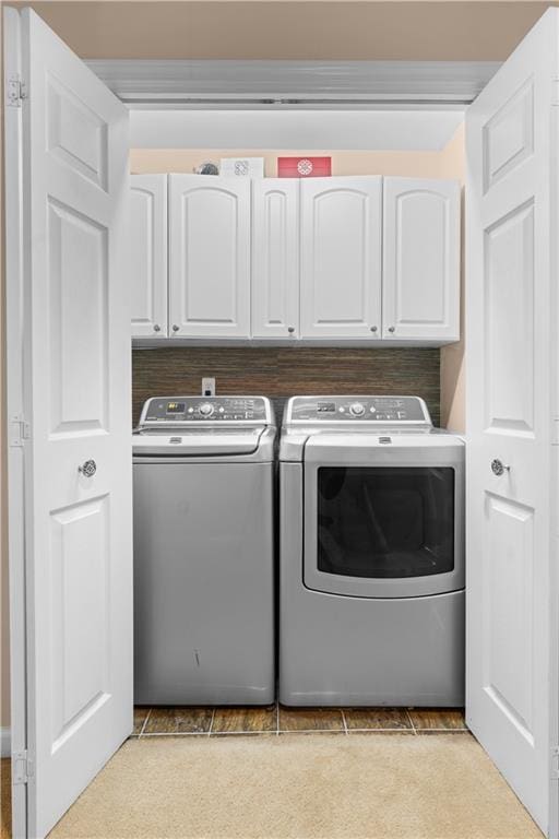 laundry room featuring cabinets and washer and clothes dryer