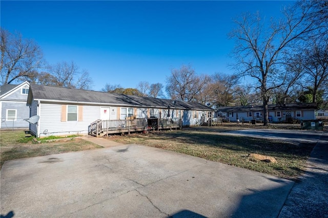 view of front of property featuring a wooden deck and a front yard